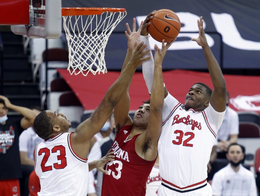 Indiana forward Trayce Jackson-Davis, center, reaches for a rebound between Ohio State forward Zed Key, left, and forward E.J. Liddell during the first half of an NCAA college basketball game in Columbus, Ohio, Saturday, Feb. 13, 2021. (AP Photo/Paul Vernon)