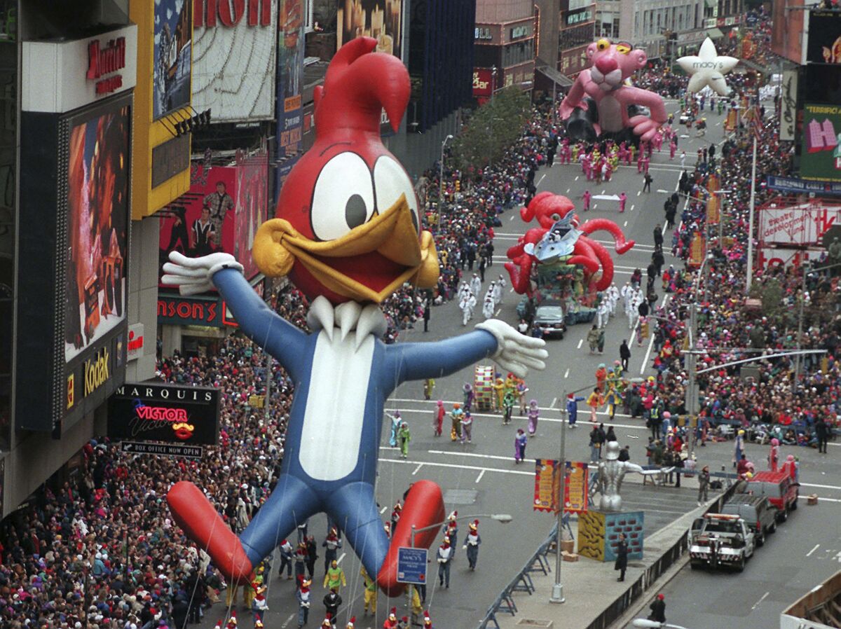FILE - In this Nov. 23, 1995 file photo Woody Woodpecker leads a line of other balloons and floats into New York's Times Square during the 69th annual Macy's Thanksgiving Day parade. A Macy's Thanksgiving parade reimagined for the coronavirus pandemic will feature floats, performers and giant balloons parading along a one-block stretch of 34th Street in front of the retailer's flagship Manhattan store, Macy's officials announced Monday, Sept. 14, 2020. (AP Photo/Paul Hurschmann, File)