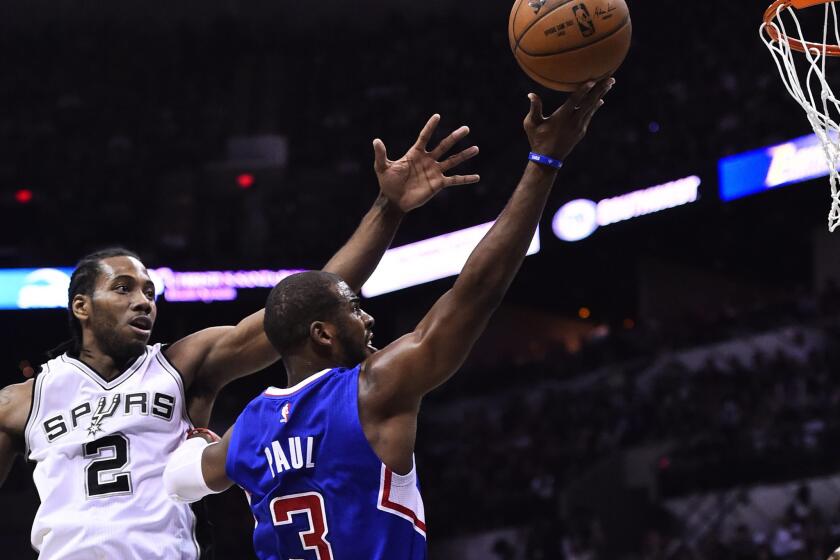 Spurs forward Kawhi Leonard tries to block the shot of Clippers guard Chris Paul from behind during the first half of Game 6.