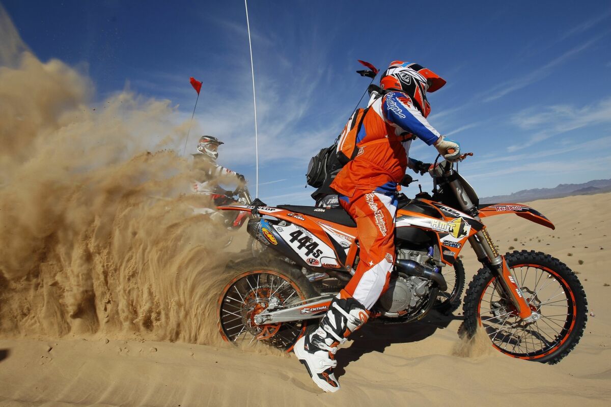A motorcycle rider revs his engine as he launches off the top of Oldsmobile Hill at the Imperial Sand Dunes on Friday.