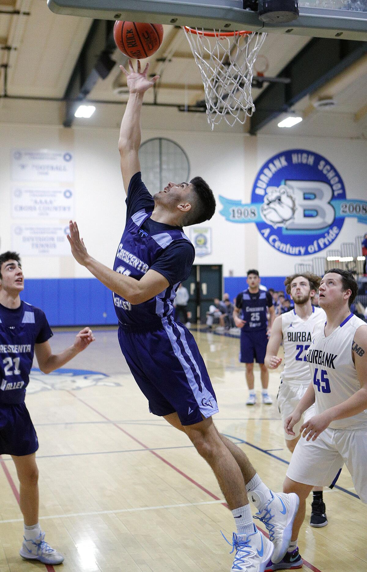 Crescenta Valley's Alec Voskanian does a reverse layup against Burbank in a Pacific League boys' basketball game at Burbank High School on Thursday, December 19, 2019.