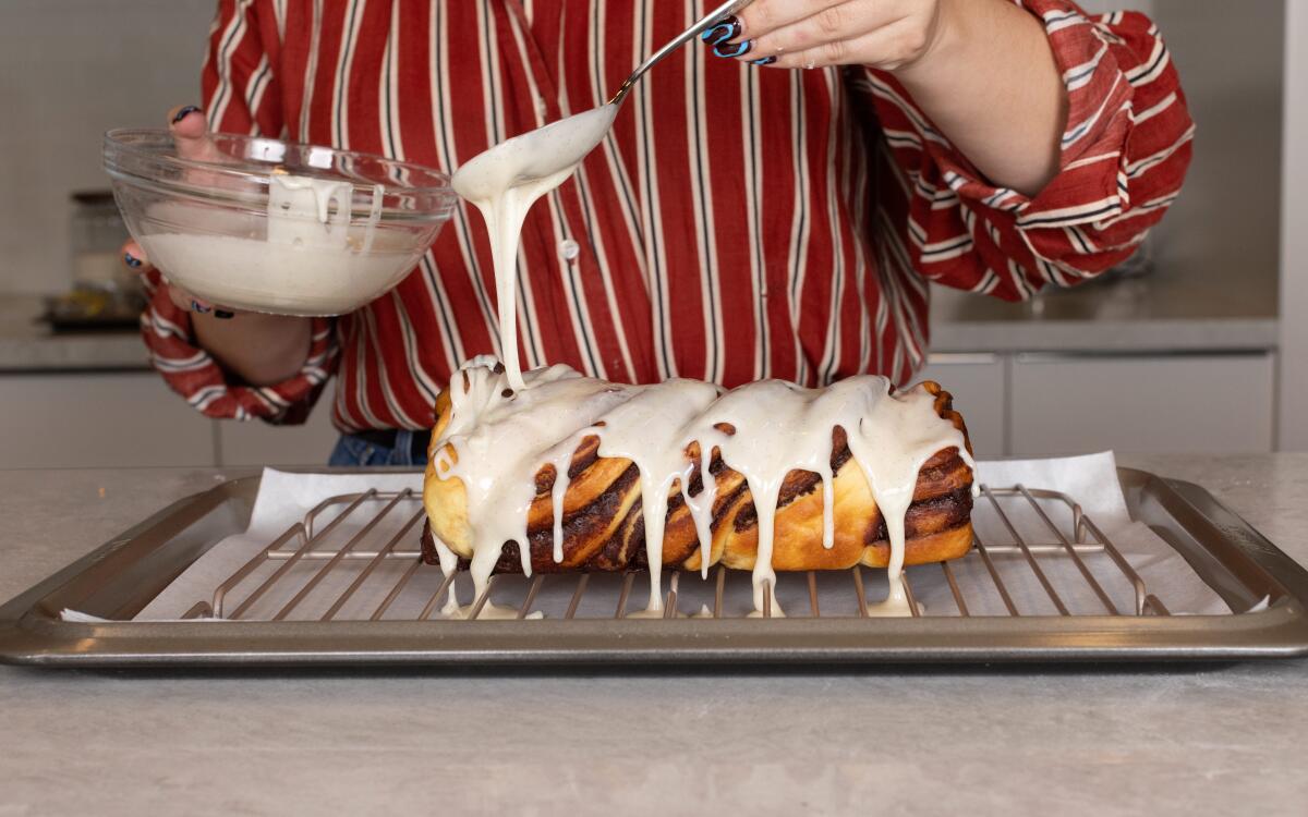 Pouring vanilla glaze over chocolate babka.