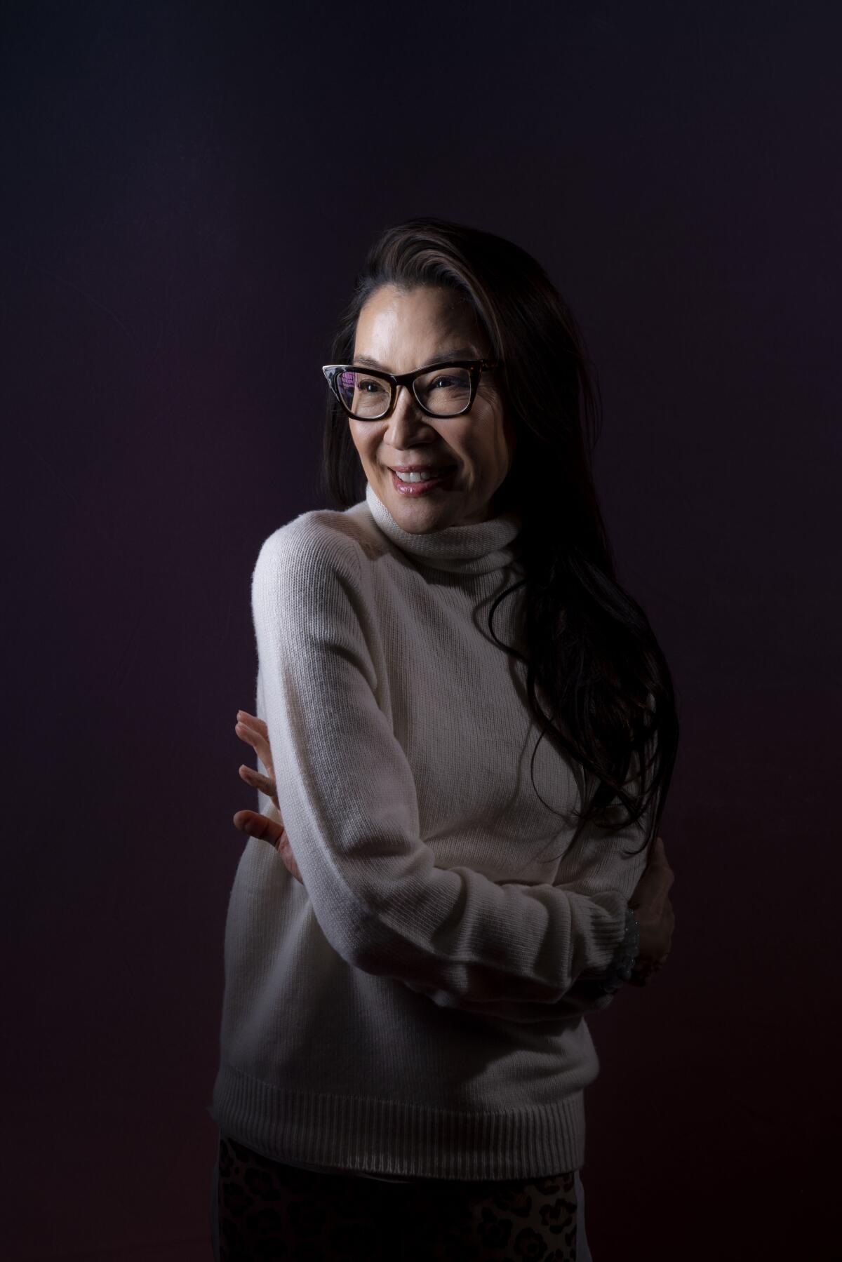 Michelle Yeoh poses for portrait with her arms across her chest.