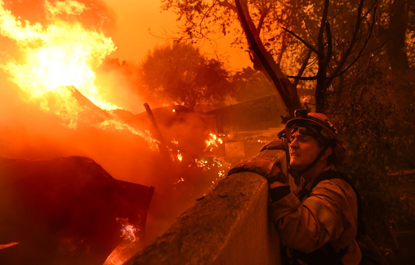 Mayor and firefighter Rick Mullen surveys a house on fire in Malibu as the Woolsey fire continues its path to the coast.