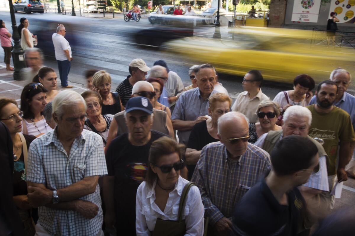Pensioners wait outside the main gate of the national bank of Greece in Athens on July 9 to withdraw money; the maximum allowed is about $132.