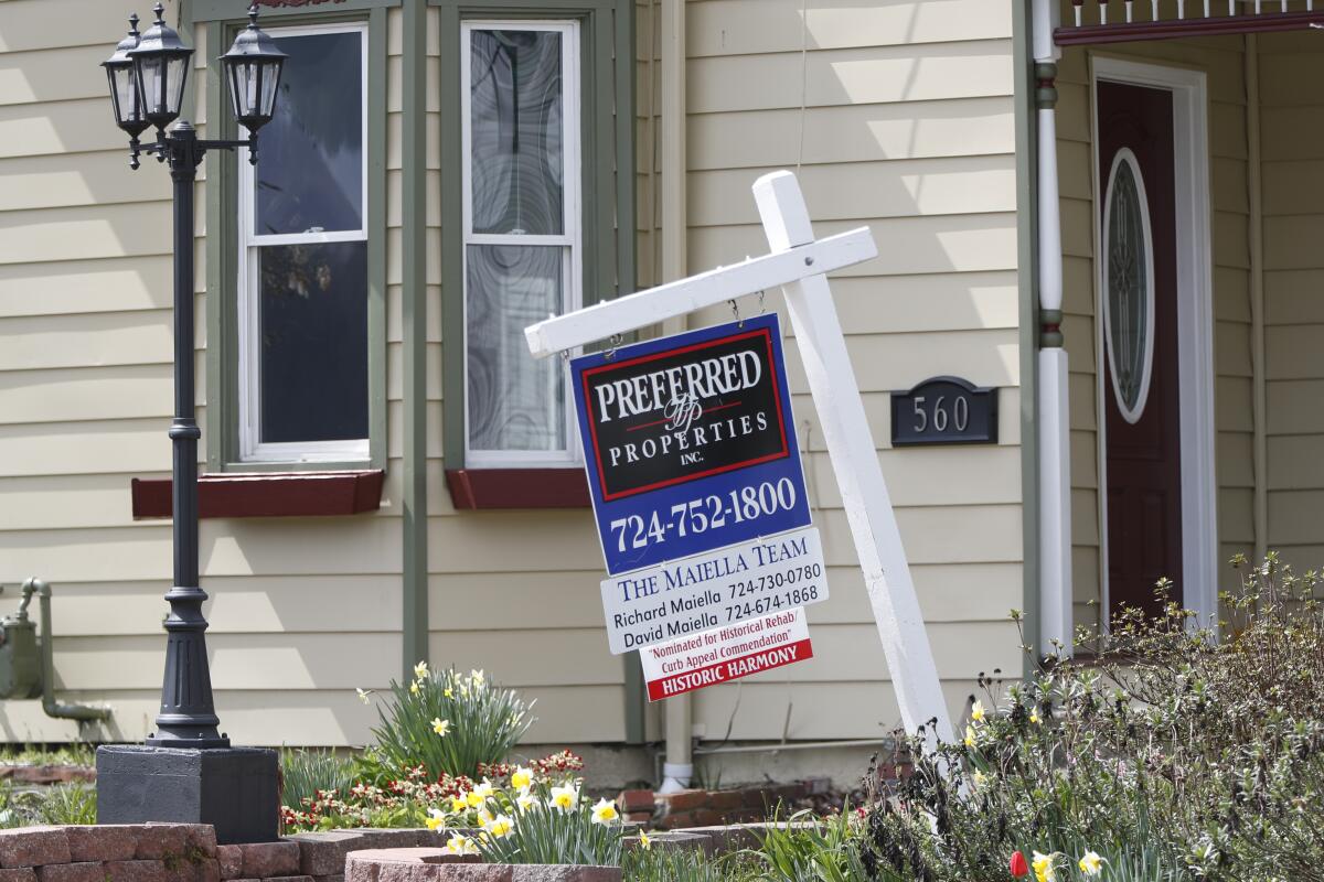 A real estate company sign in front of a home for sale in Harmony, Pa. 