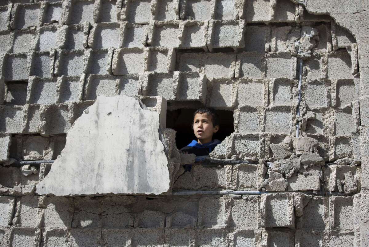 A Palestinian child looks out from a destroyed home in Beit Hanoun in the northern Gaza Strip on Jan. 30. International legal expert William Schabas has resigned from the U.N. panel examining possible war crimes during last summer's Gaza conflict.