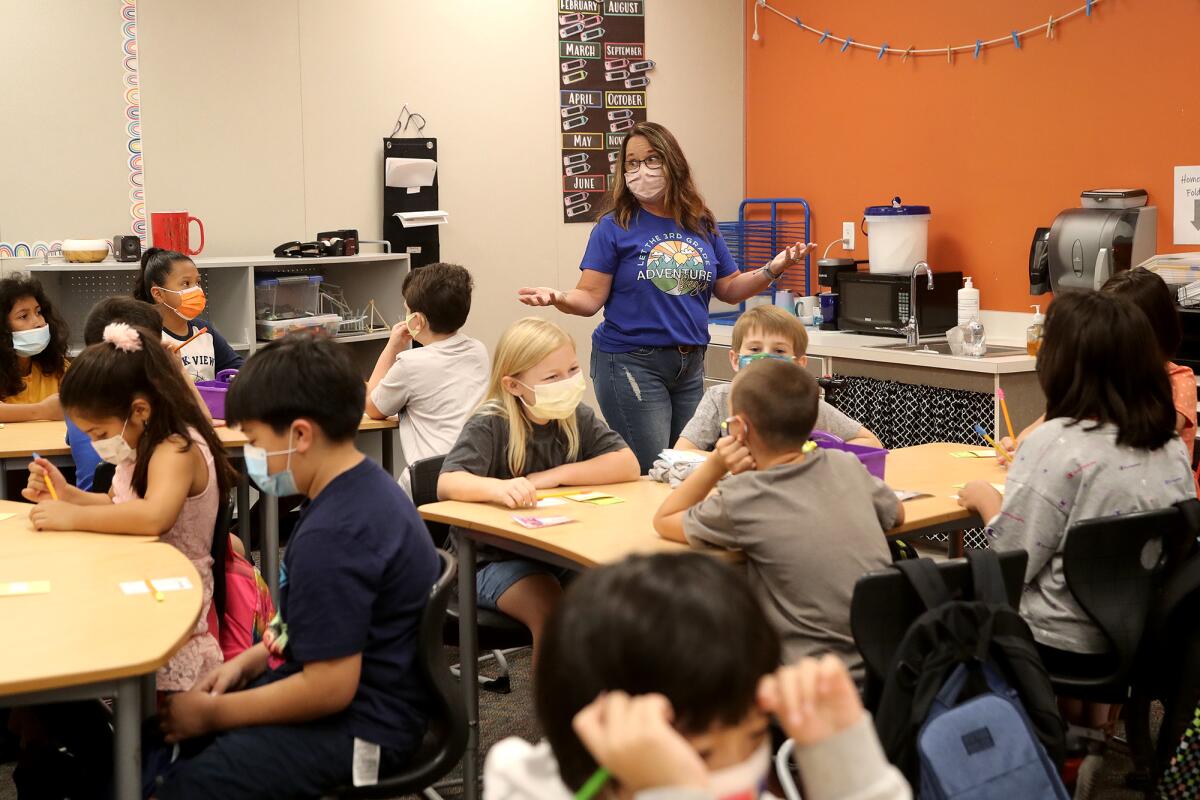 Third-grade teacher Sandi Lewis speaks to her students on their first day back on Wednesday morning.