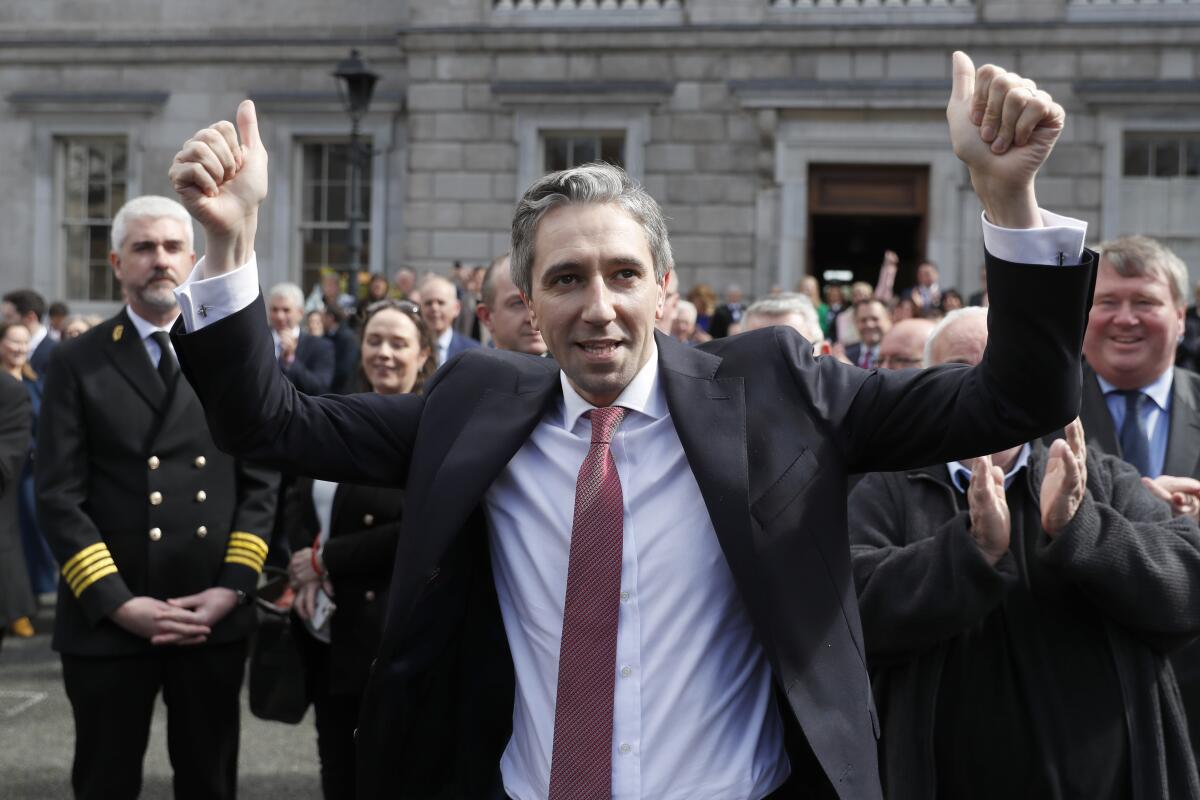 The new Prime Minister of Ireland, Simon Harris gestures as he is applauded by fellow lawmakers.