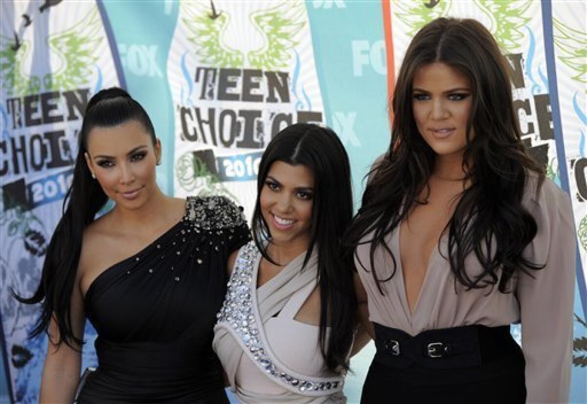 FILE - In this Aug. 8, 2010 file photo, from left, Kim Kardashian, Kourtney Kardashian and Khloe Kardashian arrive at the Teen Choice Awards in Universal City, Calif. The Kardashian sisters are seeking to cut ties with a venture that sold prepaid debit cards under their name after coming under attack for the card's high fees. (AP Photo/Chris Pizzello, File)