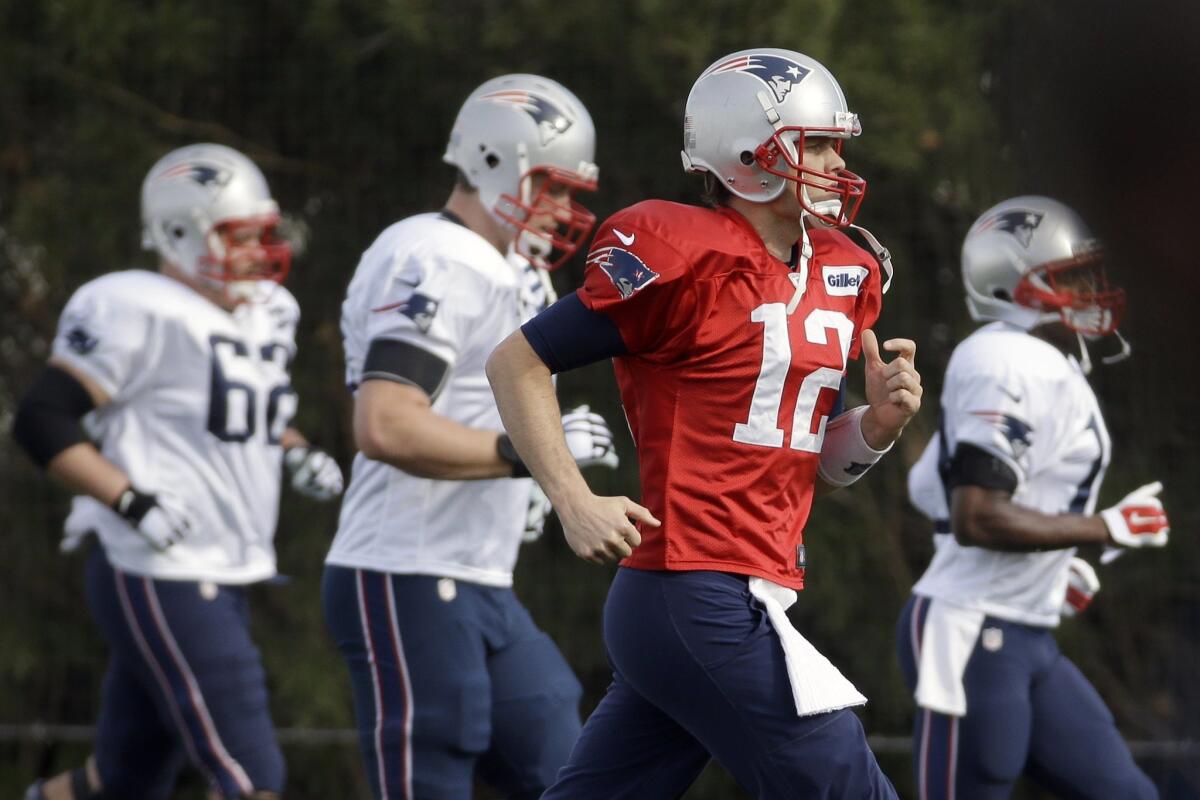 New England quarterback Tom Brady (12) warms up with teammates during practice Wednesday in Tempe, Ariz.