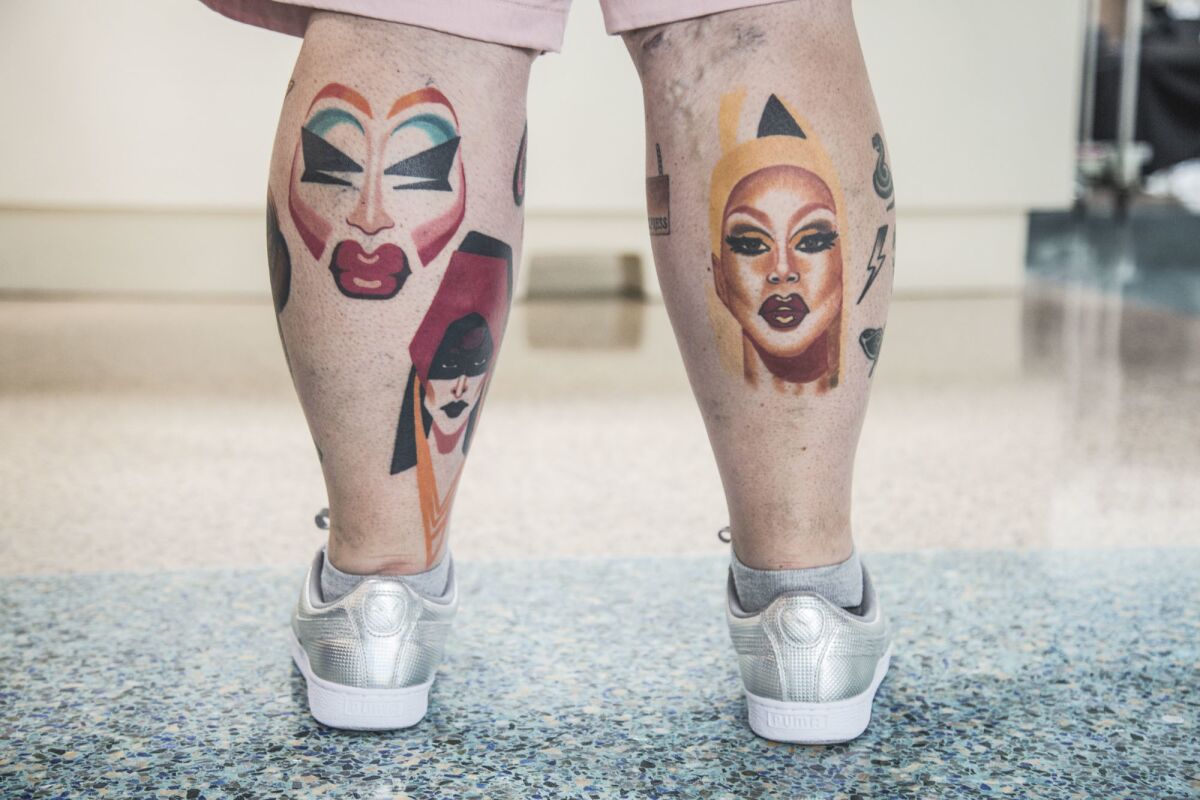 James Robinson shows off his tattoos of Trixie Mattel, left, Detox, middle, and RuPaul, right, during RuPaul's DragCon LA at the Los Angeles Convention Center.