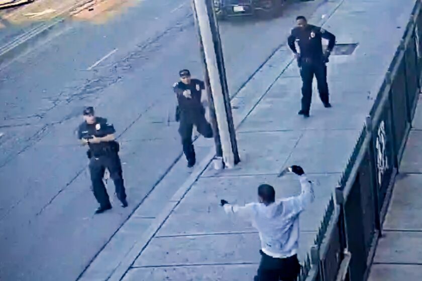 Huntington Park police released video of three officers approaching Anthony Lowe as he hobbles away. He is seen carrying a knife, which police said he had used to stab a man, and raises it above his head. (Huntington Police Department)