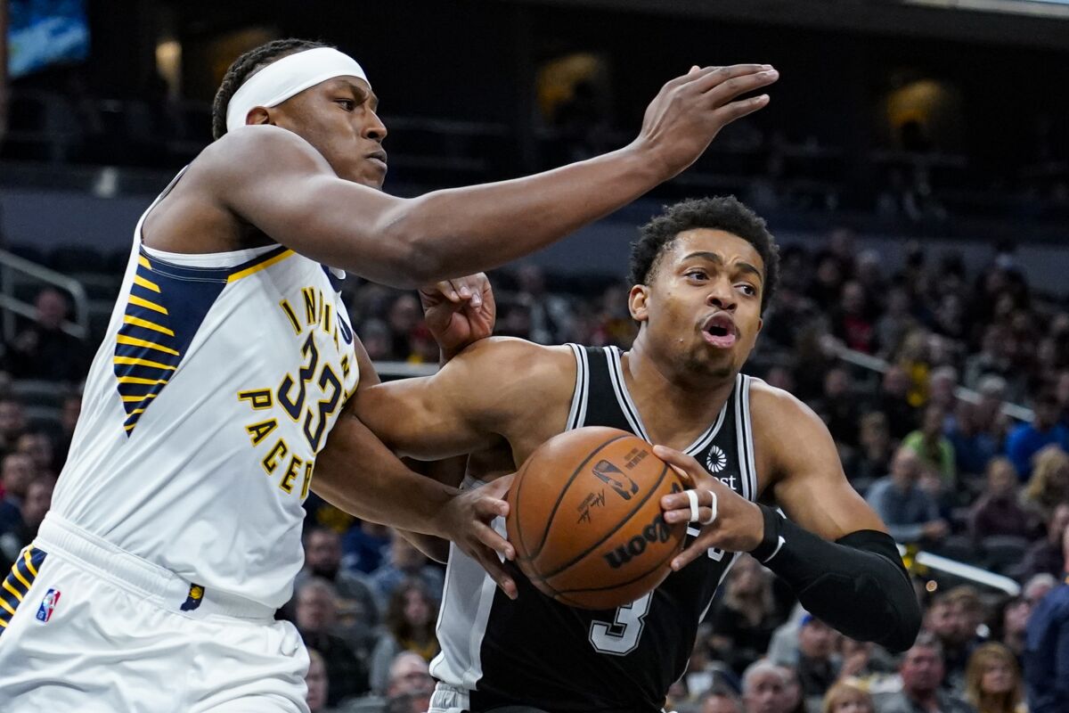 San Antonio Spurs forward Keldon Johnson (3) drives on Indiana Pacers center Myles Turner (33) during the first half of an NBA basketball game in Indianapolis, Monday, Nov. 1, 2021. (AP Photo/Michael Conroy)