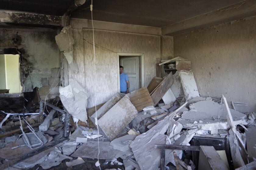 Vladimir Golubenko looks at his office damaged by a drone during a night attack, in Kyiv, Ukraine, Sunday, May 28, 2023. Ukraine's capital was subjected to the largest drone attack since the start of Russia's war, local officials said, as Kyiv prepared to mark the anniversary of its founding on Sunday. (AP Photo/Vasilisa Stepanenko)