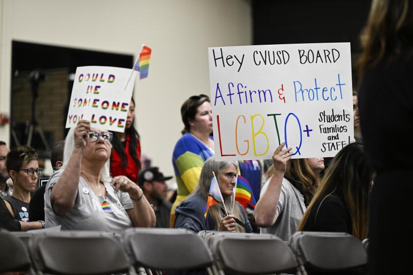 FILE - Parents, students, and staff of Chino Valley Unified School District hold up signs in favor of protecting LGBTQ+ policies at Don Antonio Lugo High School, June 15, 2023, in Chino, Calif. Californians won't be voting this November on a policy that would have required schools to notify parents if their child asks to change their gender identification. Proponents of a ballot measure to create such a statewide policy announced Tuesday, May 28, 2024, that they failed to collect enough signatures to put the measure before voters this fall. (Anjali Sharif-Paul/The Orange County Register via AP, File)