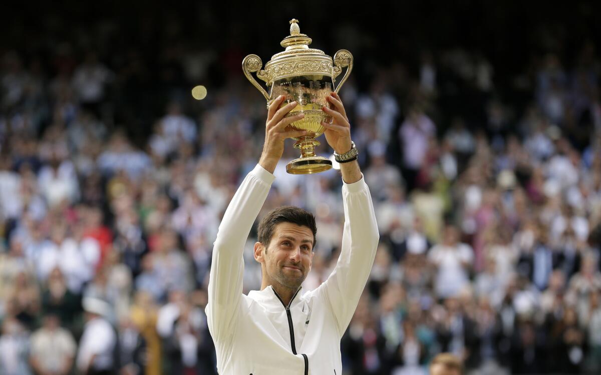 Novak Djokovic celebrates with the Wimbledon championship trophy after defeating Roger Federer on Sunday.