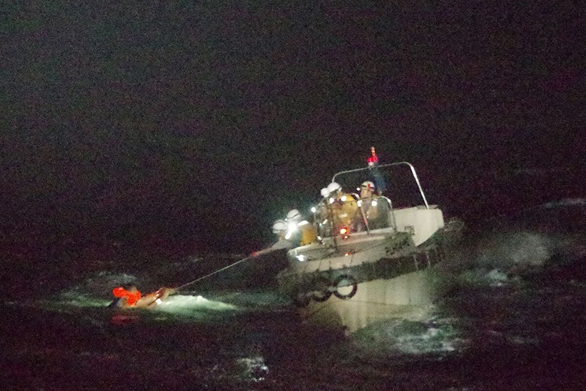 A crewman of a Panamanian cargo ship is rescued by Japanese Coast Guard members Wednesday.