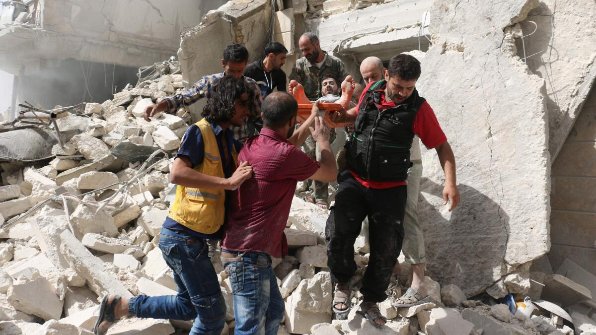 Syrians remove a victim from the rubble of a destroyed building following a reported air strike in the Qatarji neighbourhood of the northern city of Aleppo on September 21.