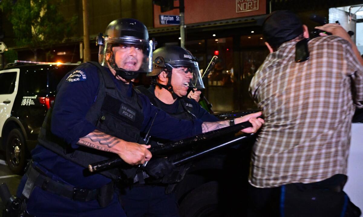 Police use batons to disperse a crowd