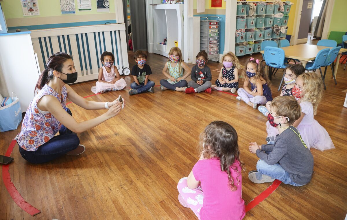 A teacher works with students at Le Petite Etoile 360 Preschool in San Diego. 
