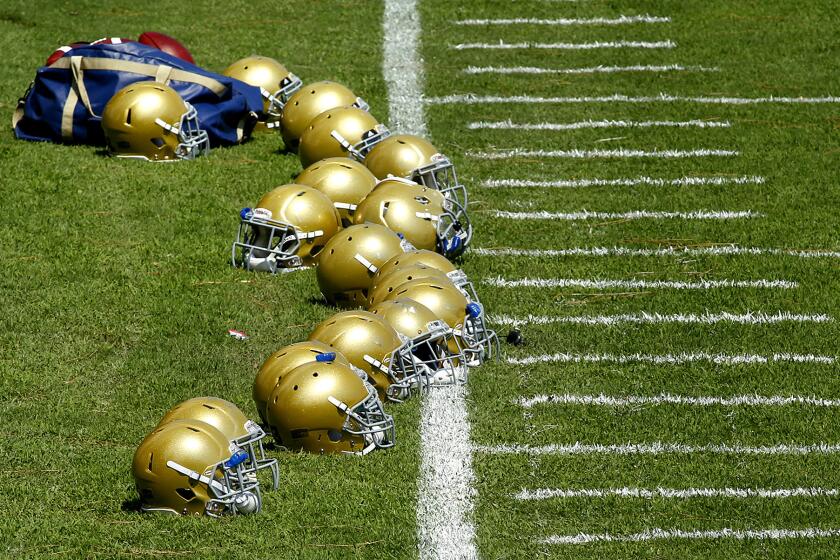 UCLA helmets sit on the field during UCLA's practice session at Cal State San Bernardino on Monday.