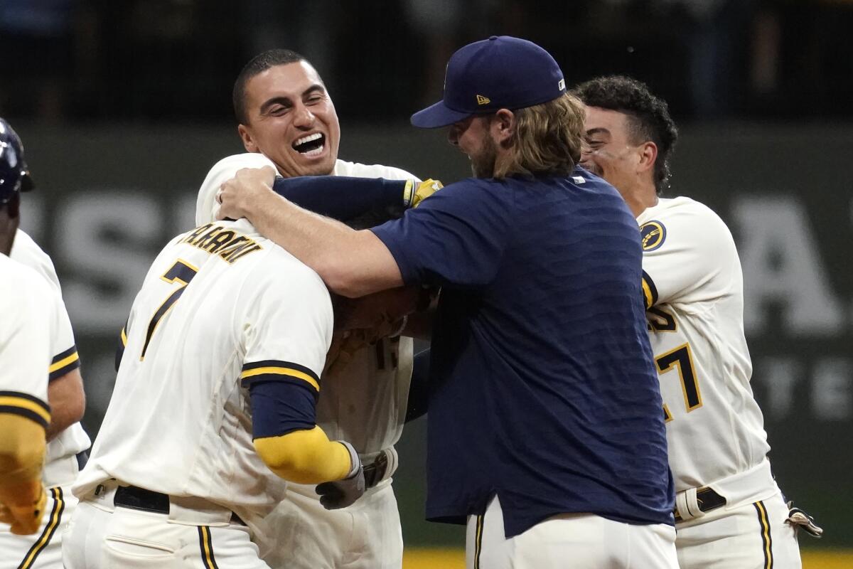 Milwaukee Brewers' Victor Caratini is congratulated by teammates.