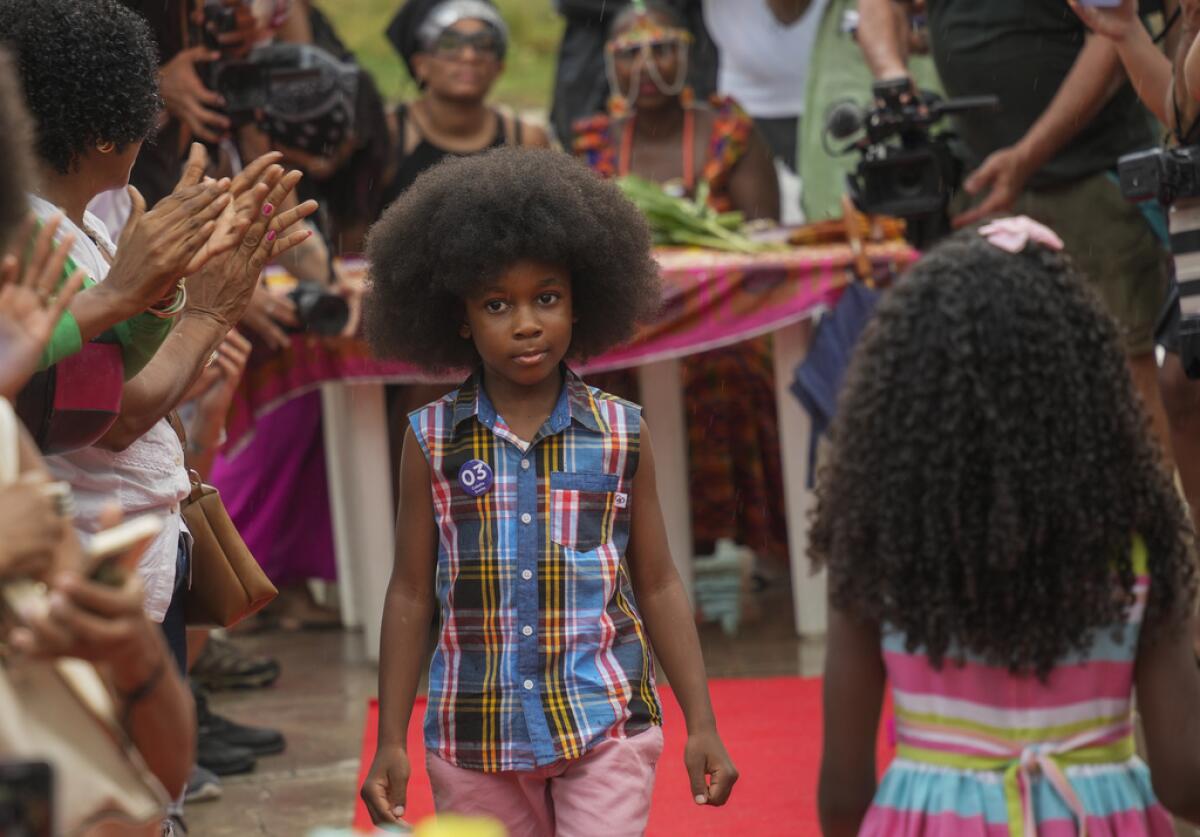 Niños caminan por la pasarela en un desfile