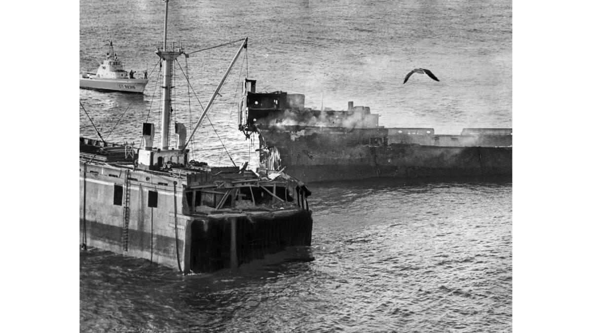 Nov. 15, 1961: Smoke billows from stern section of the broken freighter Dominator at Palos Verdes. A salvager was burning spoiled meat and other refuse, causing firemen ashore and at sea to answer alarm.
