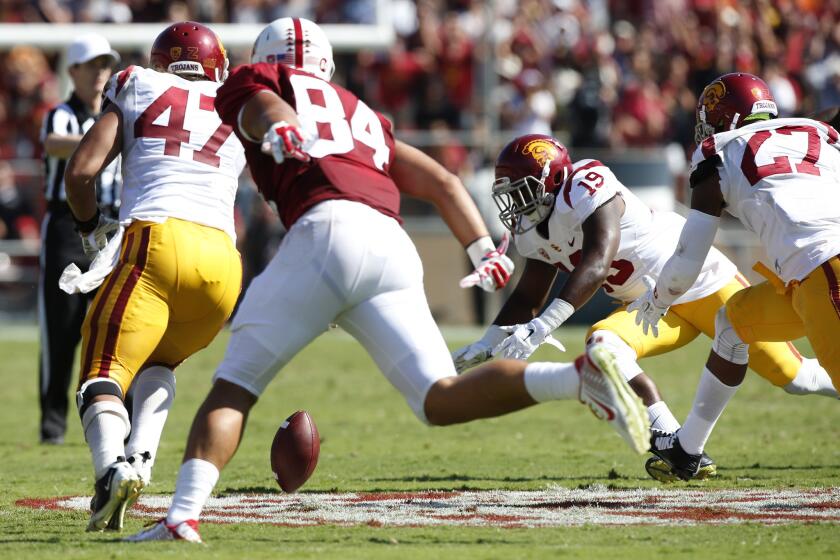 USC defensive players Scott Felix (47), Michael Hutchings (19) and Gerald Bowman move in on a loose ball against Stanford.