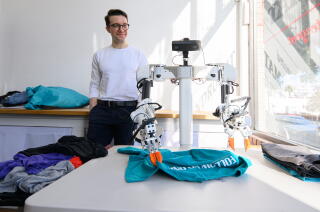 Weave Robotics co-founder Evan Wineland observes one of the company's robots as it folds laundry.