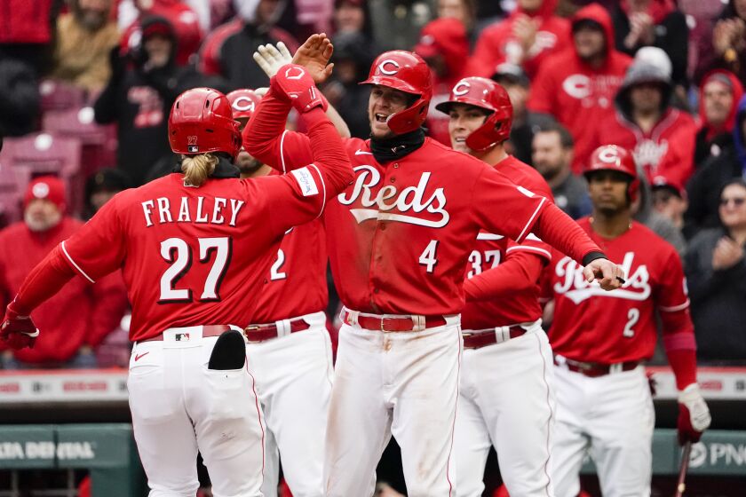 Cincinnati Reds' Wil Myers (4) congratulates teammate Jake Fraley (27) after Fraley hit a three-run home run during the sixth inning of a baseball game against the Pittsburgh Pirates, Saturday, April 1, 2023, in Cincinnati. (AP Photo/Joshua A. Bickel)