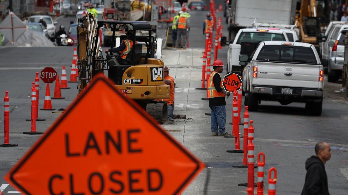 Construction crews conduct repairs on Broadway in San Francisco last year. Road construction firms are providing a major portion of the funds to defeat an initiative that would repeal an increase in state gas taxes.
