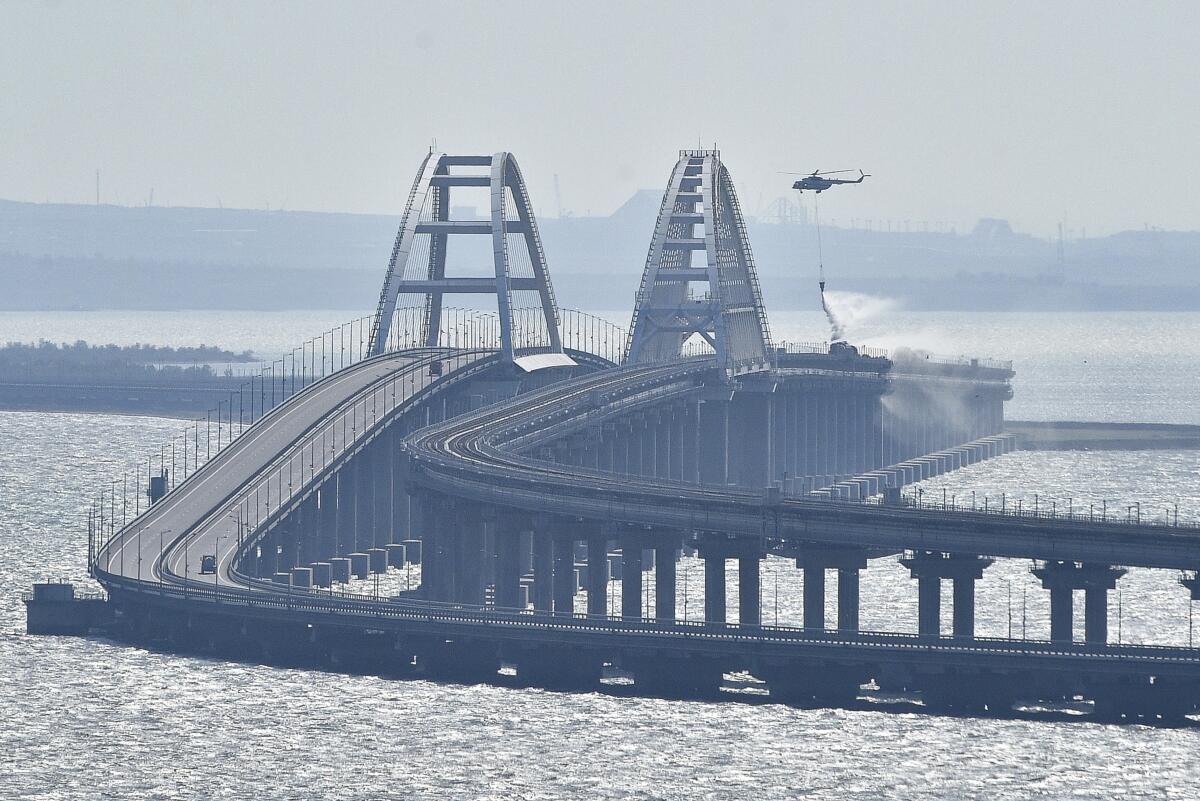 Un helicóptero arroja agua sobre un puente para sofocar un incendio