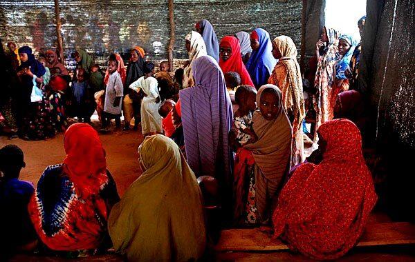 Somali refugees hold their children as they wait to be seen at one of the five health stations run by the Doctors Without Borders aid group in the Dadaab camp. Every day, more than 1,000 refugees arrive at the camp gates.