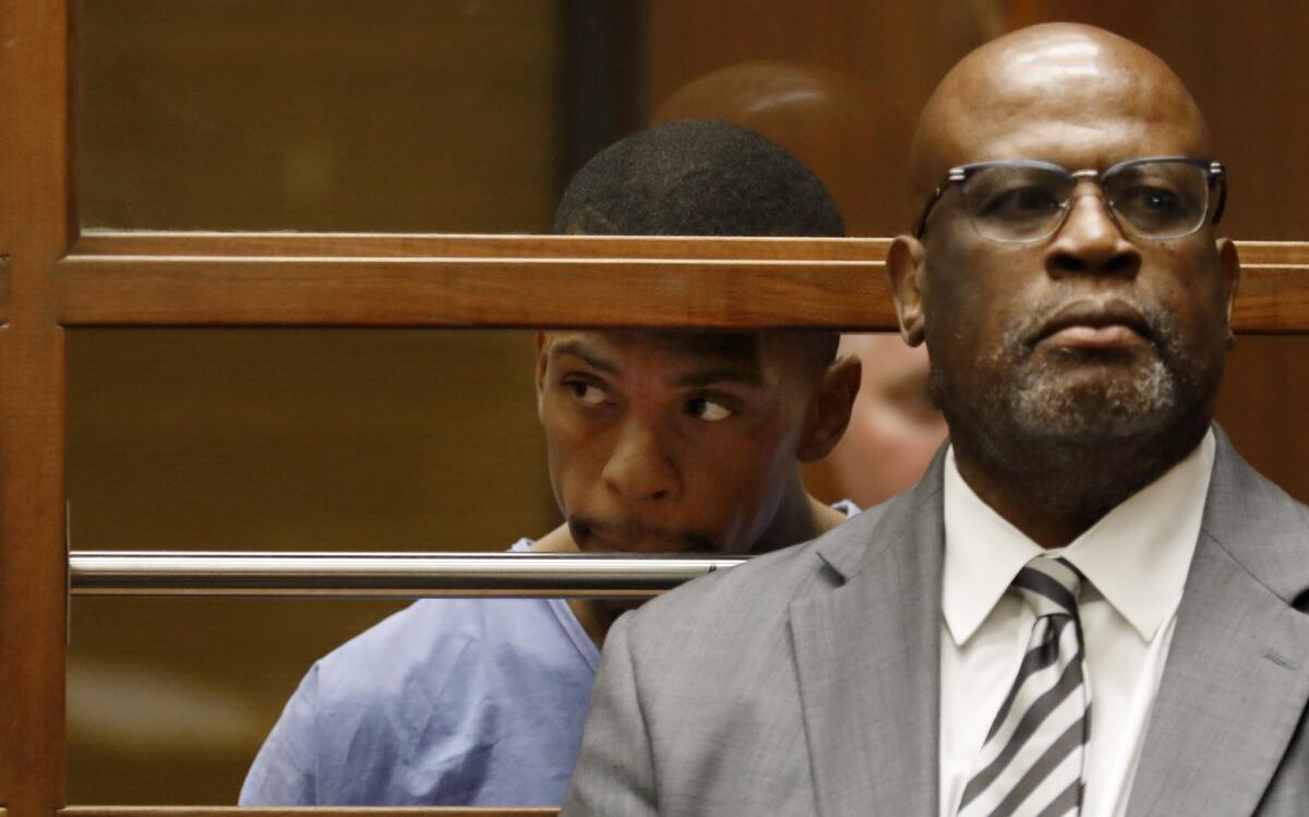 Eric Holder, appears in a downtown Los Angeles courtroom charged with one count of murder, two counts of attempted murder and one count of possession of a firearm by a felon. At right is his attorney Chris Darden.