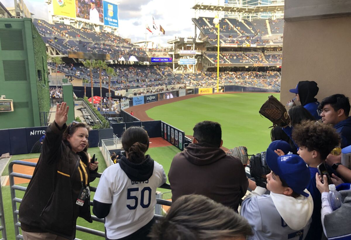 Fans crowd the rail to get a glimpse of Pades and Dodgers pitchers warming up in the bullpens.