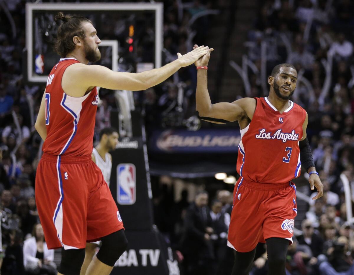 Clippers point guard Chris Paul (3) and teammate Spencer Hawes celebrate after a basket against the Spurs in the second half.