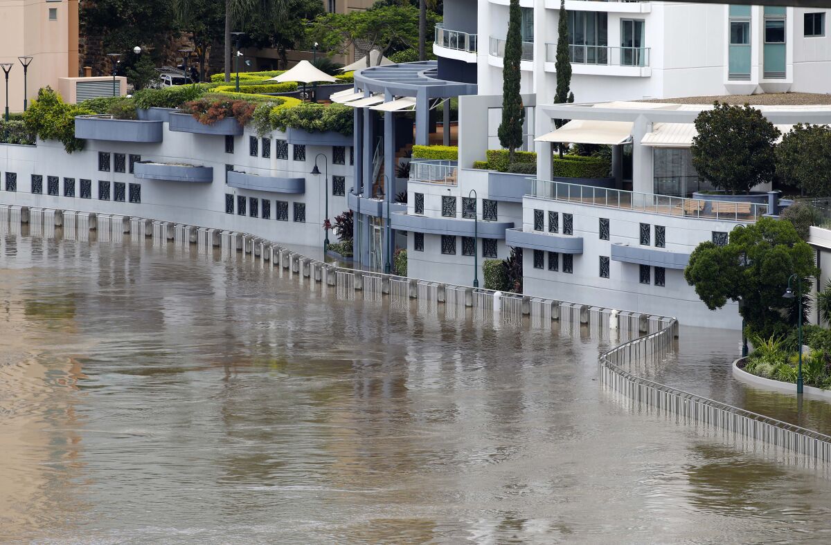 Floodwaters flow into an apartment building on the river in Brisbane, Australia, Wednesday, March 2, 2022. Tens of thousands of people had been ordered to evacuate their homes and many more had been told to prepare to flee as parts of Australia's southeast coast are inundated by the worst flooding in decades. (AP Photo/Tertius Pickard)