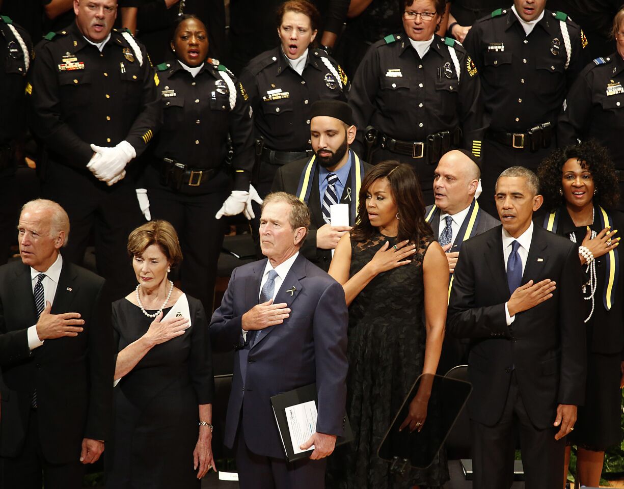 Vice President Joe Biden, left, Laura Bush and former President George W. Bush join President Obama and First Lady Michelle Obama at the memorial service in Dallas for five slain policemen.