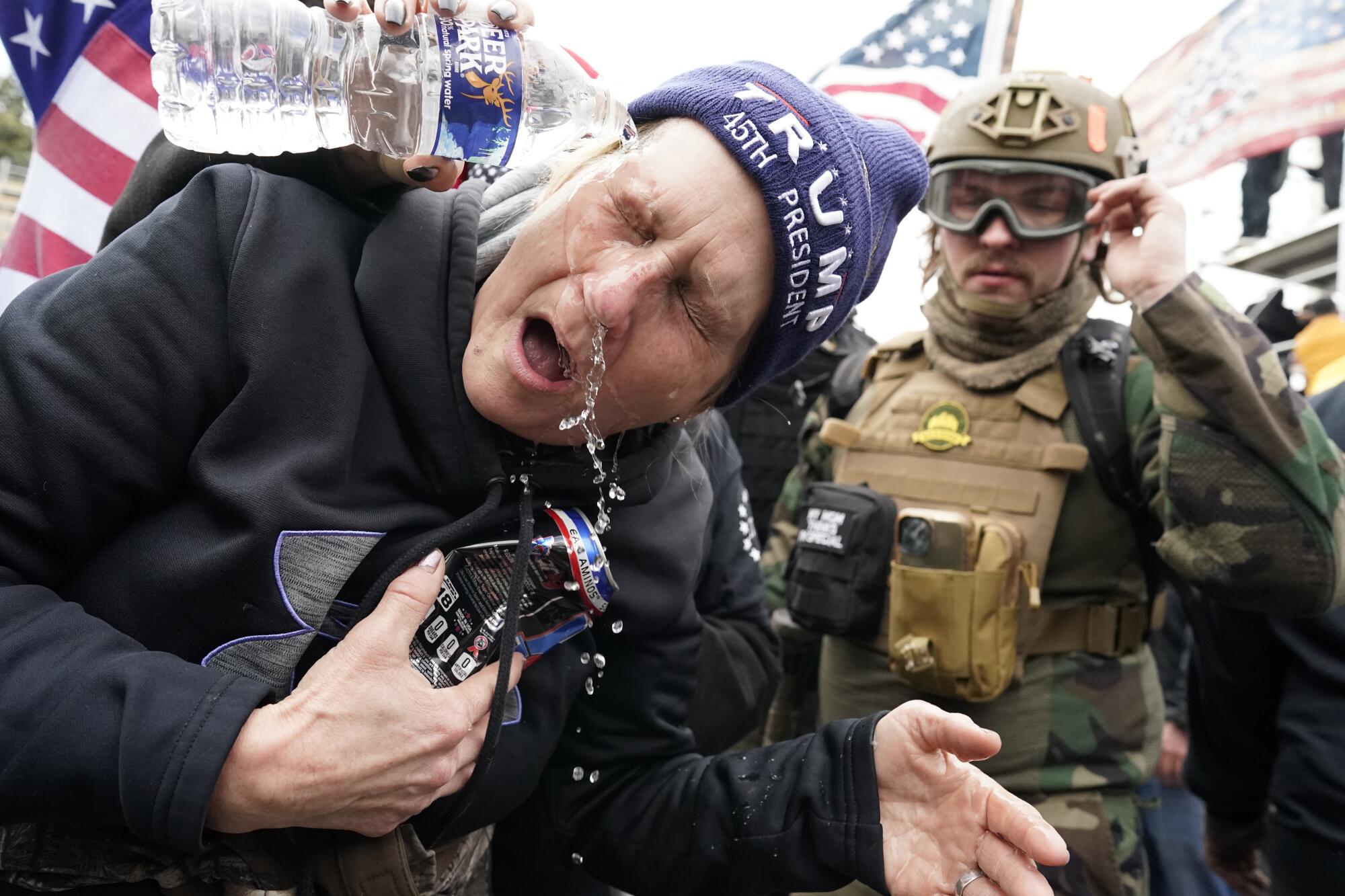 A protester has water poured in their eyes after being tear gassed.