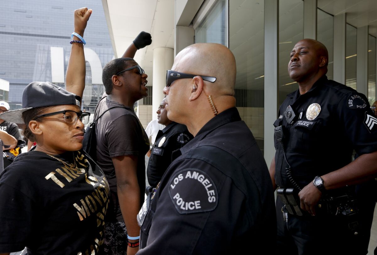 Jasmine Richards faces off with a Los Angele police officer after she and other protesters disrupted an L.A. Police Commission meeting on the one-year anniversary of Ezell Ford's death.
