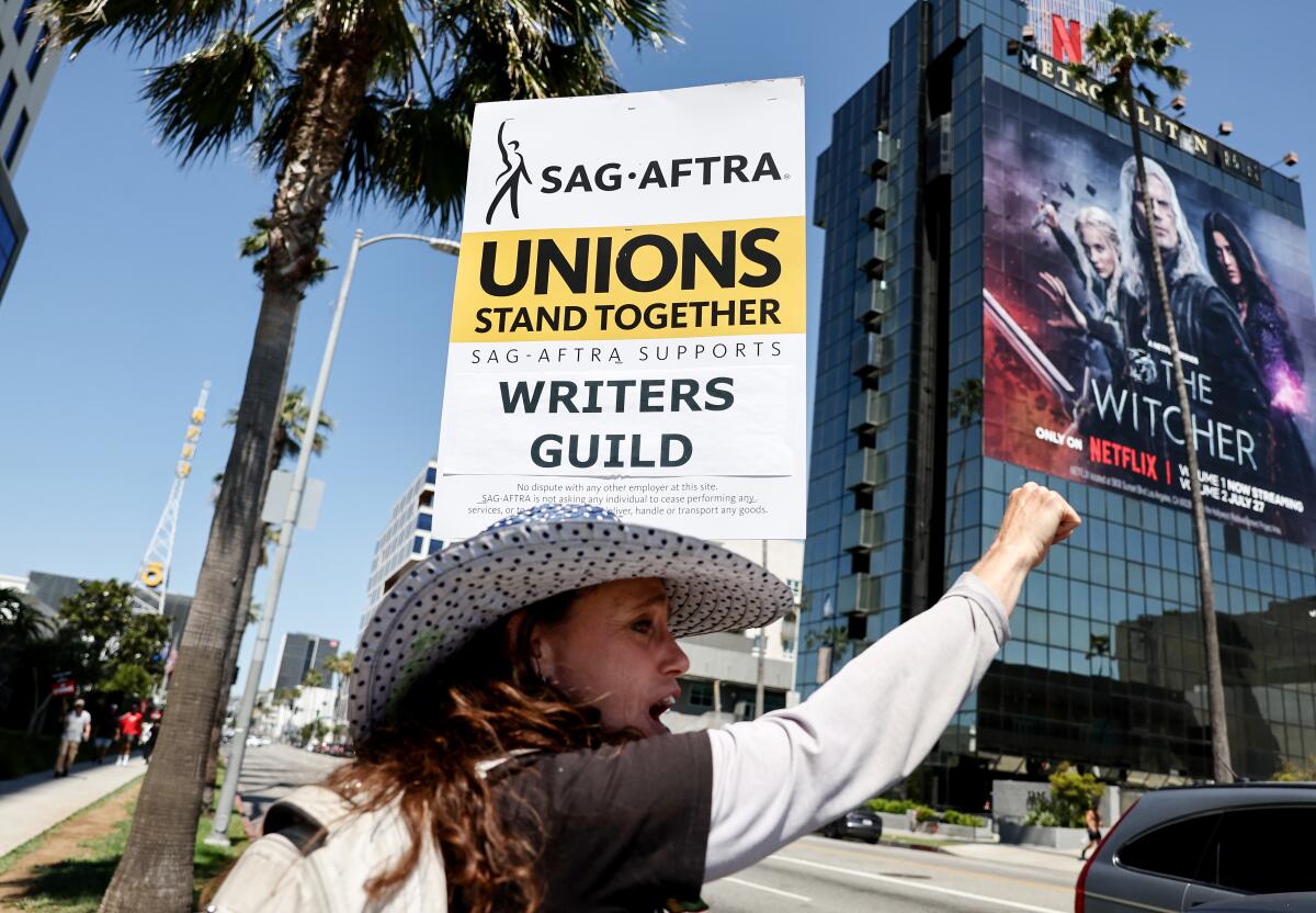 SAG-AFTRA member Christine Robert pickets in solidarity with striking WGAworkers outside the offices of Netflix.