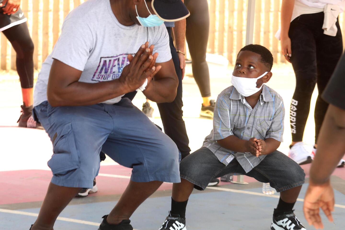 Bejamin Cole II shows son Barreth Cole, 5, an exercise routine at Watts Empowerment Center.