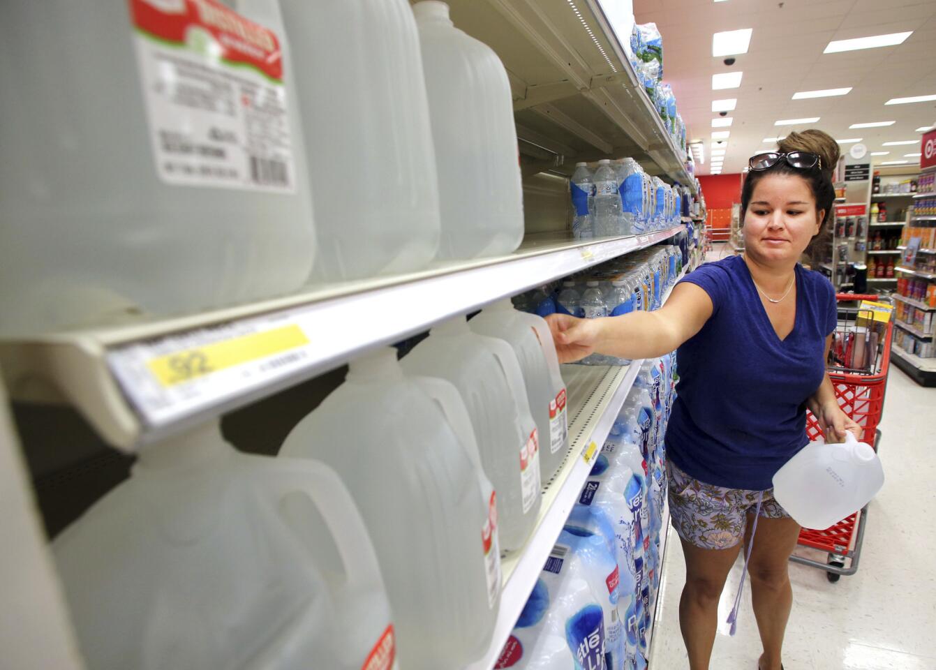 Kelby Schweickerrt, of Destin, Fla., grabs some gallon jugs of drinking water from the shelves at the Target store in Destin on Sept. 5, 2017.