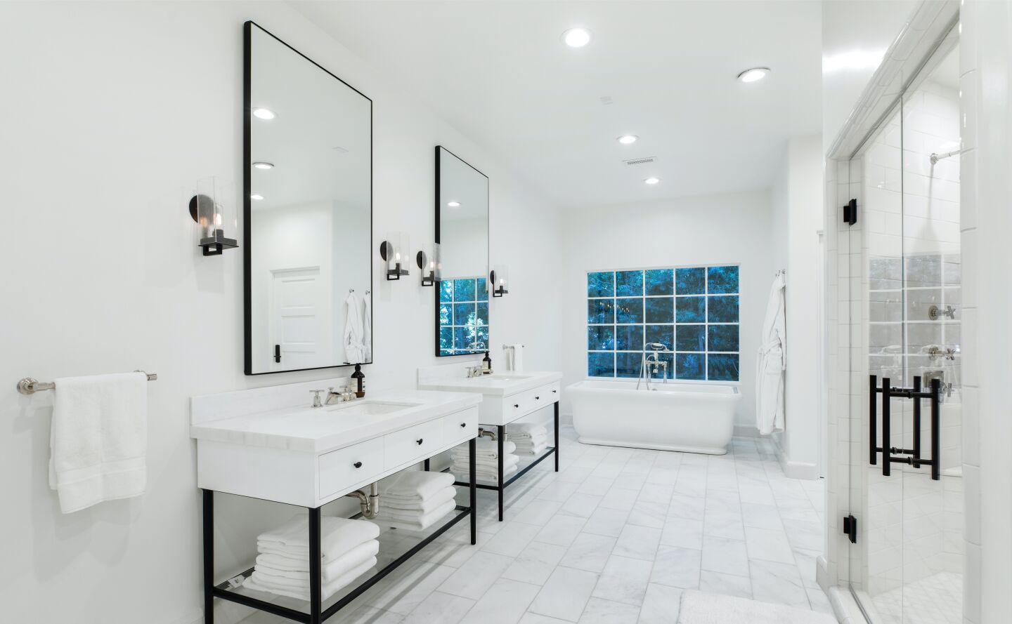 White walled and green and blue tiled bathroom with his and her vanities, a tub and tiled floor.