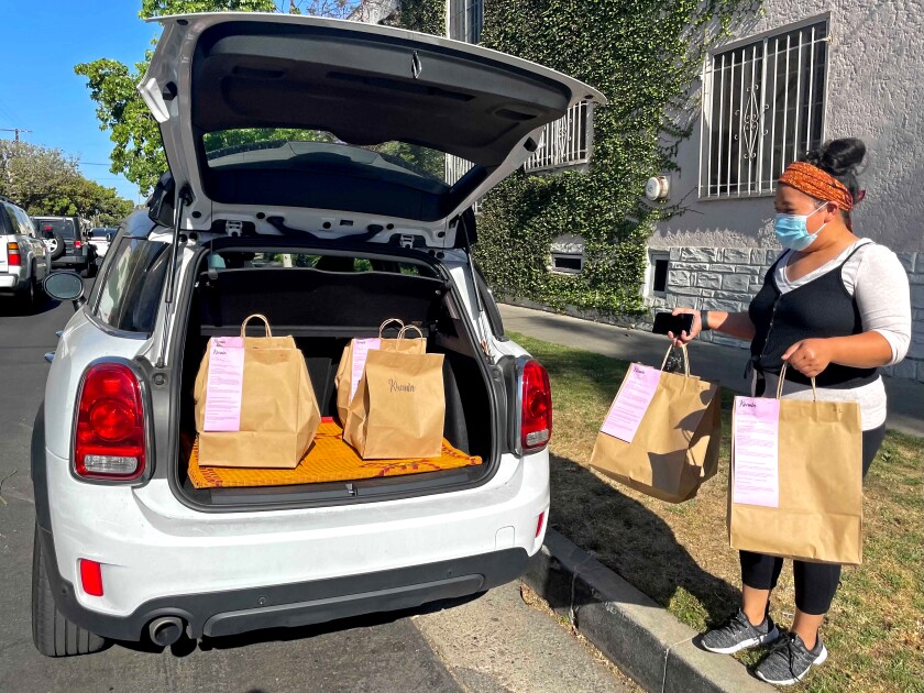 Phert Em loads dinner orders for her Cambodian-inspired pop-up, Khemla, into her Mini Cooper.