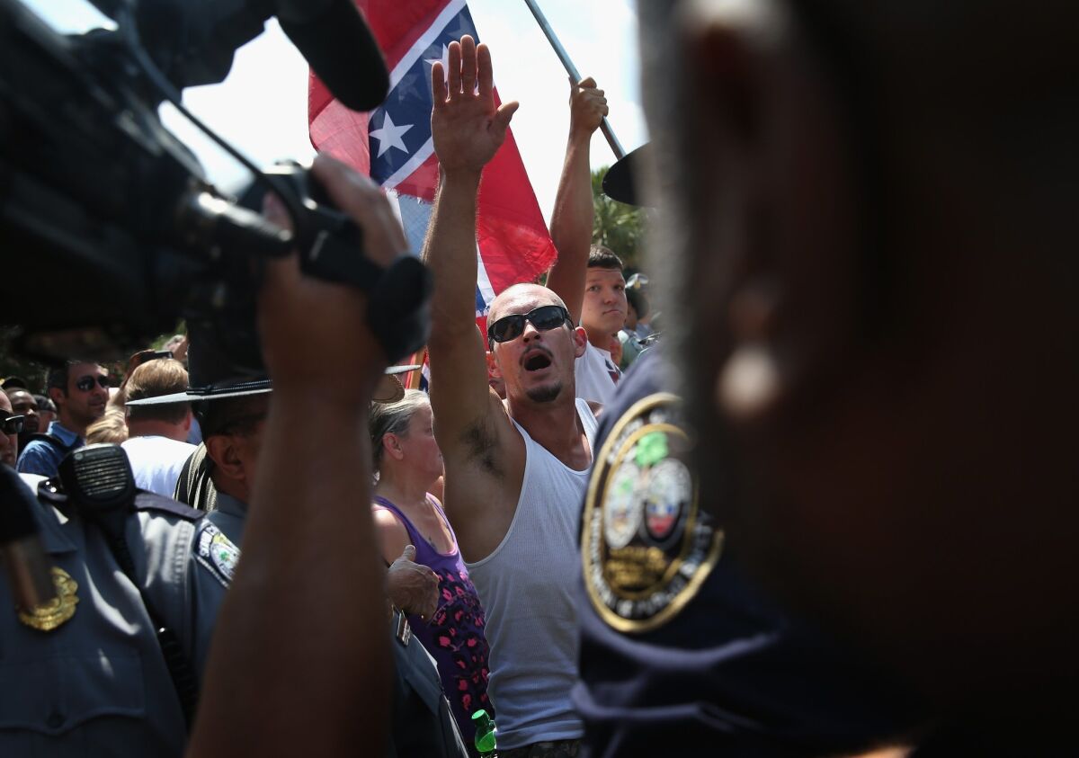 Ku Klux Klan members give the Nazi salute during a demonstration at the state house building on July 18, 2015, in Columbia, S.C.