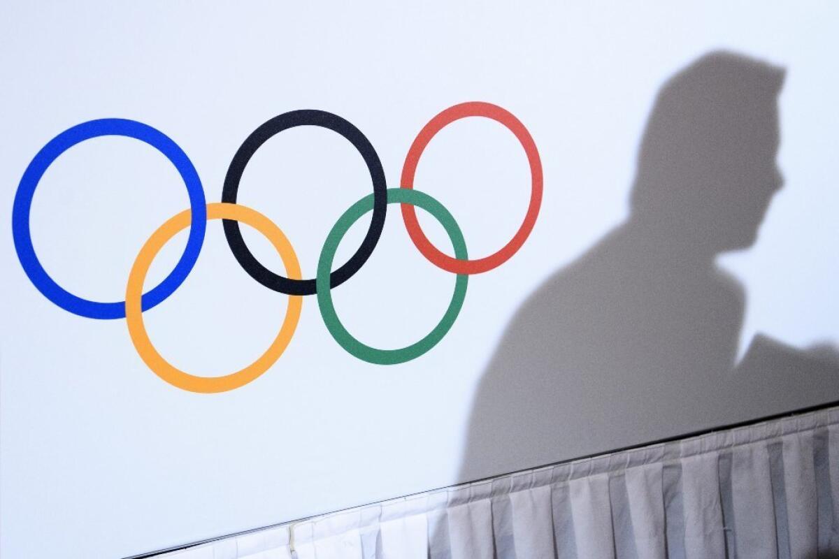 The shadow of a journalist next to the Olympic Rings during a press conference of International Olympic Committee President Thomas Bach on Dec. 08, 2016.