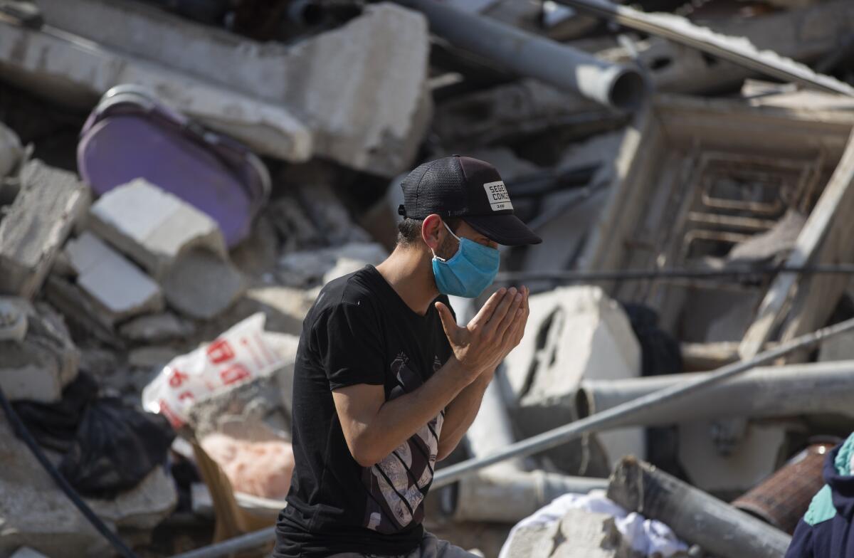 Un palestino reza frente a los escombros de un edificio 
